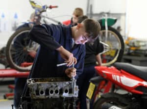 An automotive learner working on an engine