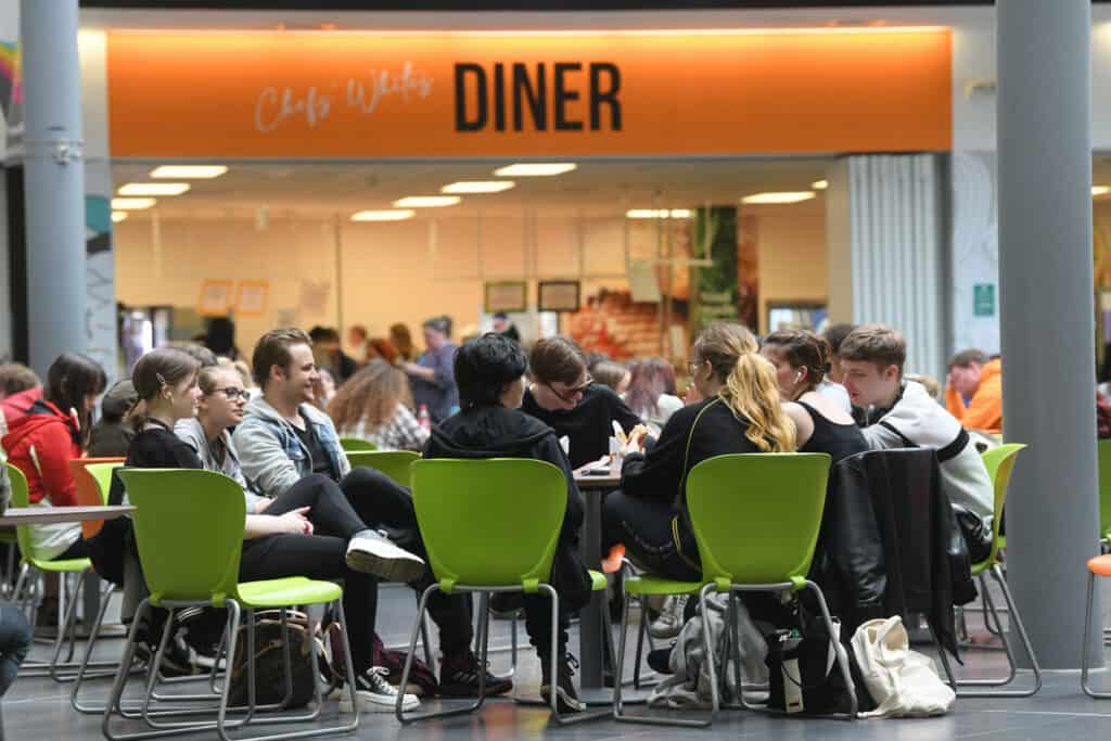 Mixed learners enjoying themselves in the Ipswich campus atrium at lunch time.