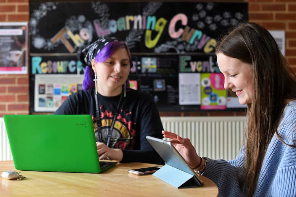 Two learners using laptops in the learning curve.