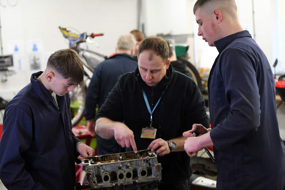 Automotive lecturer demonstrating to learners