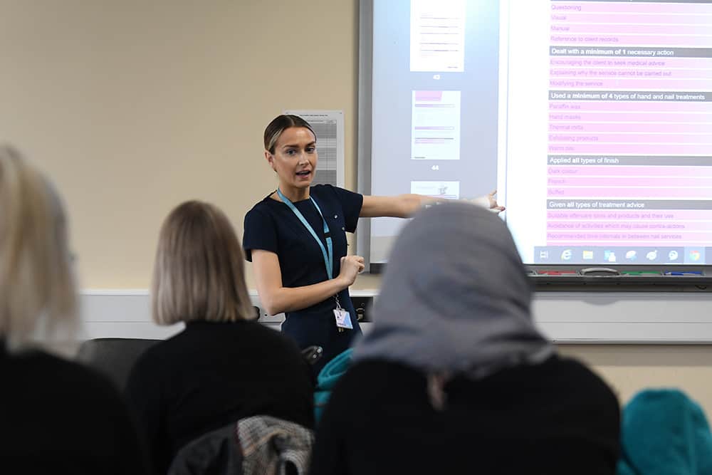 Beauty lecturer teaching session with the use of an interactive whiteboard.