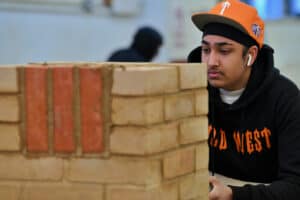 Learner pointing up brickwork