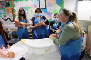 Lecturer demonstrating child bathing techniques