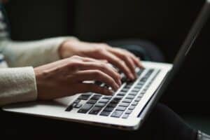 Adult typing on a laptop keyboard