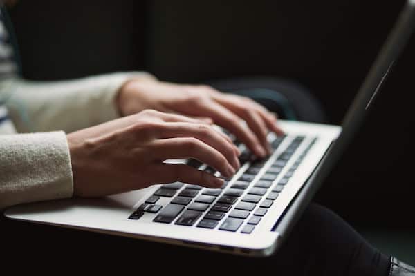 Adult typing on a laptop keyboard