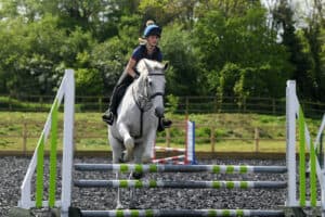 A learner jumping a white horse