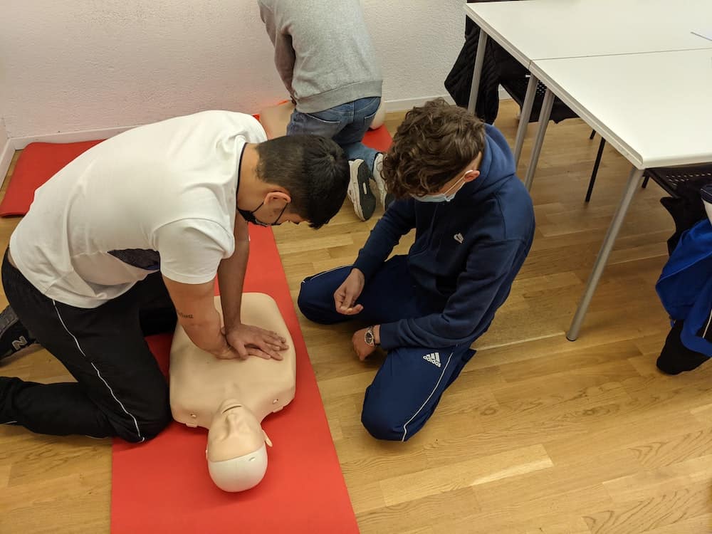 Photo of learners with a resus doll in a first aid training session