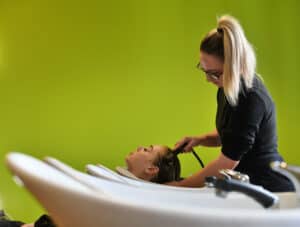 A learner in our Aura salon washing hair