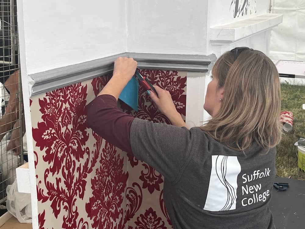A learner demonstrating wallpapering at a show