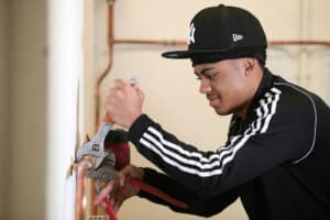 Learner using grips to tighten a fitting