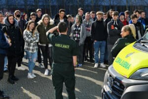 An ambulance crew talks to public services learners outside the college.
