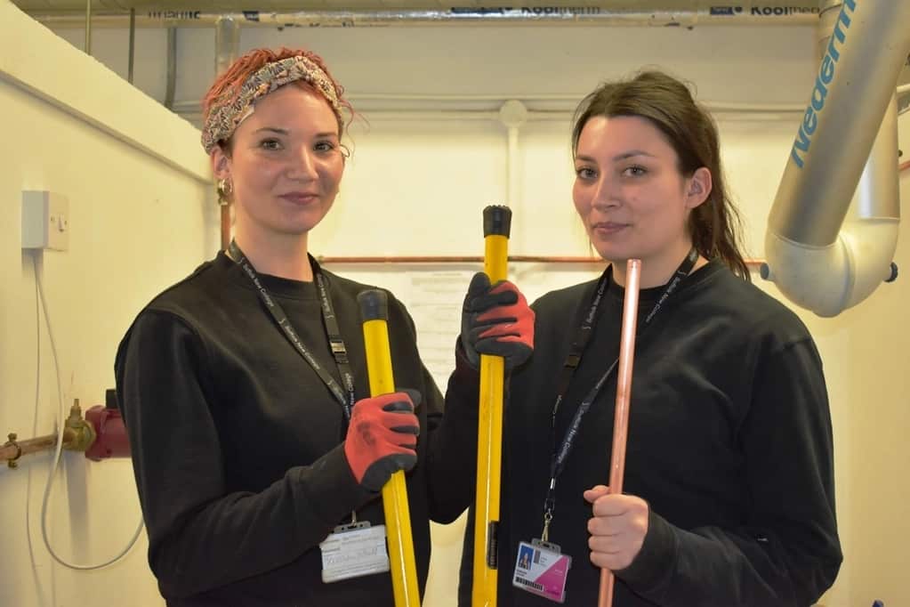 Kayleigh And Shelby Reid in a plumbing workshop