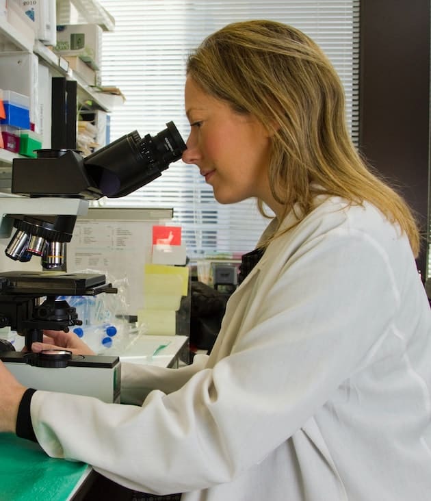 A diagnostic worker using a microscope