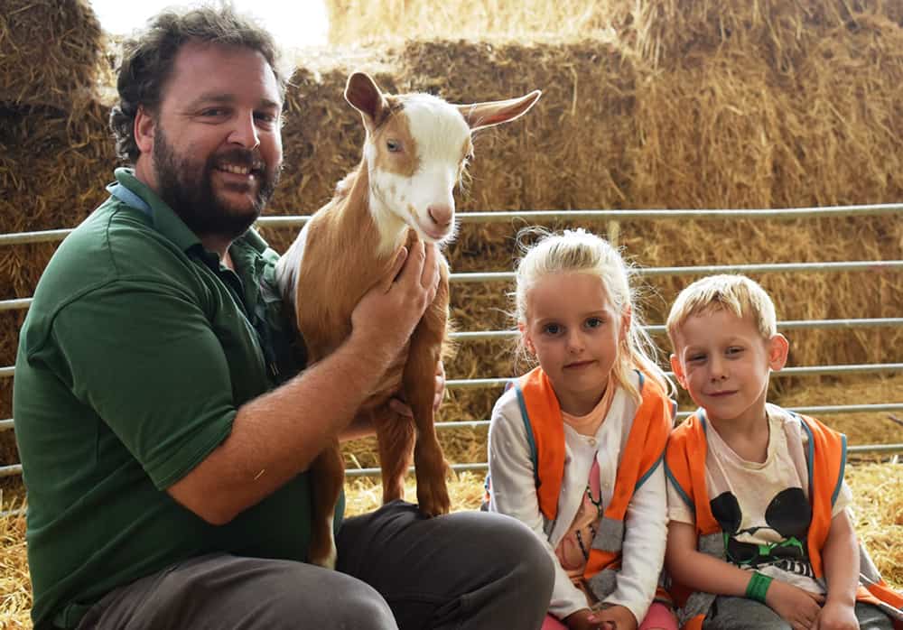 Patrick Wrenn with a guernsey goat and Cliff lane students