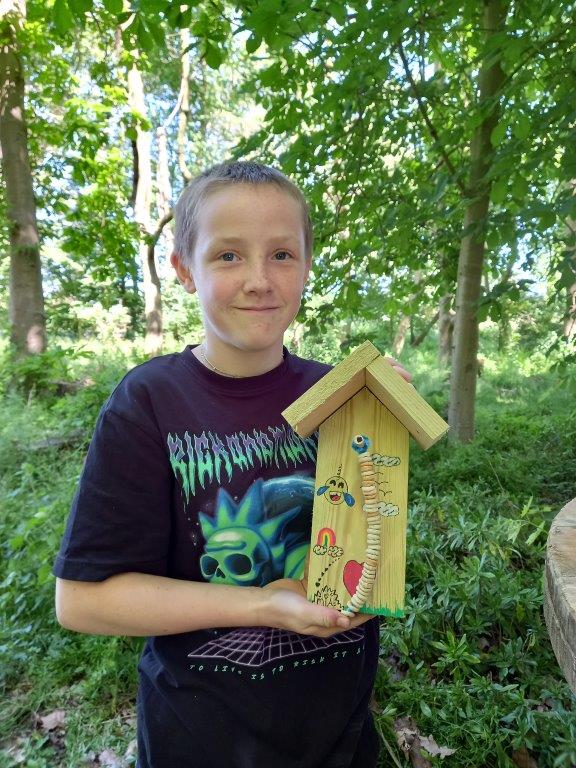 a student from wetheringsett manor school showing his bird feeder