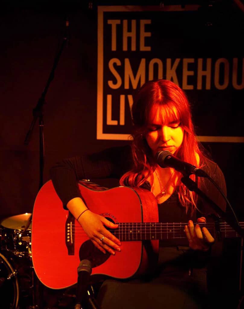 Livia Roberts playing guitar at The Smokehouse venue in Ipswich