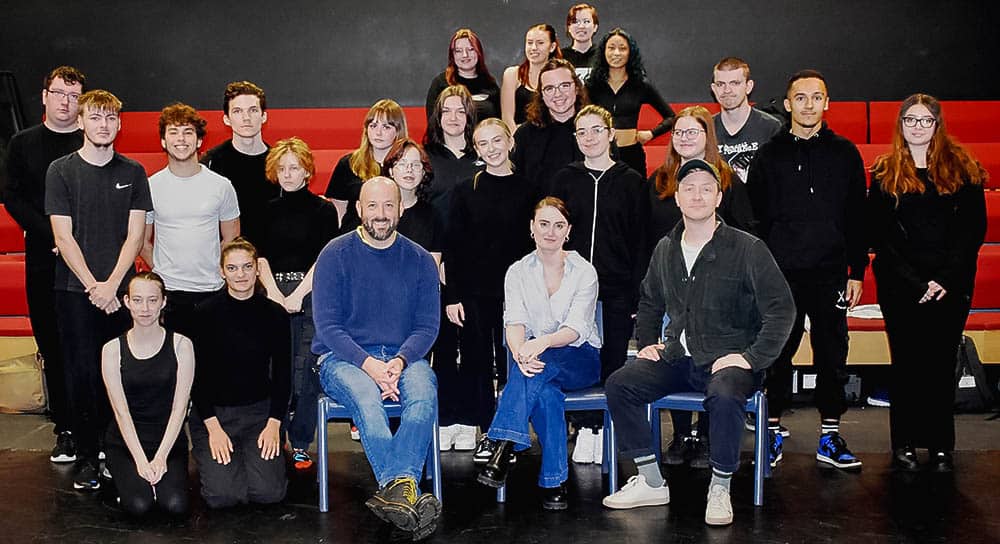 Actors and students pose for a photo in the theatre at suffolk new college