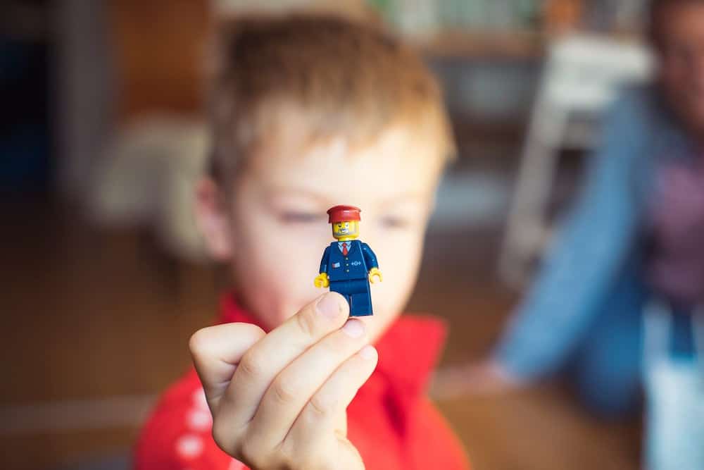 A child holding up a lego minifigure