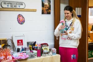 Learner Arranging Stock In The College Shop
