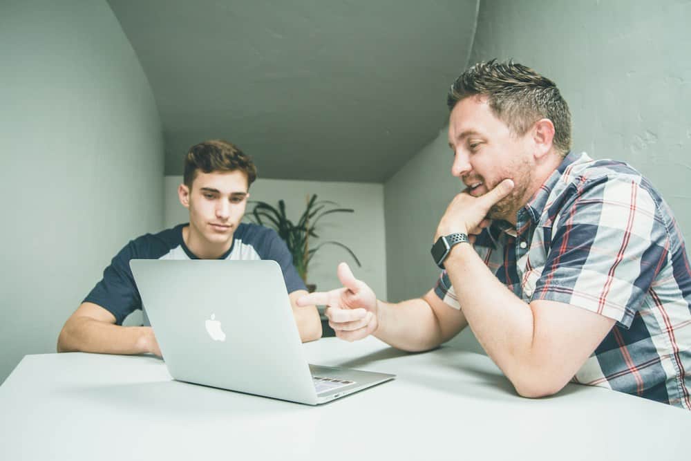 An adult and learner looking at a computer screen during a meeting.