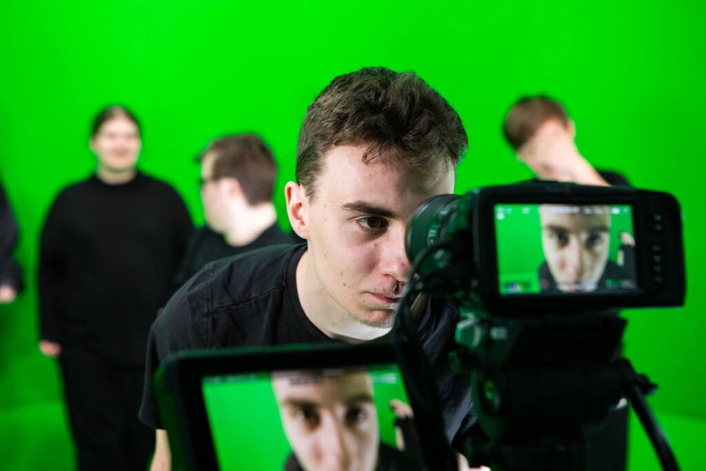 Learner in a green room with recording equipment