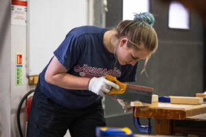 Carpentry student sawing