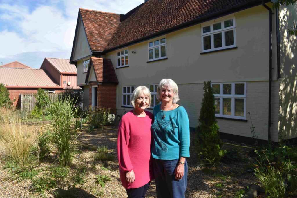 Women standing outside farmhouse 