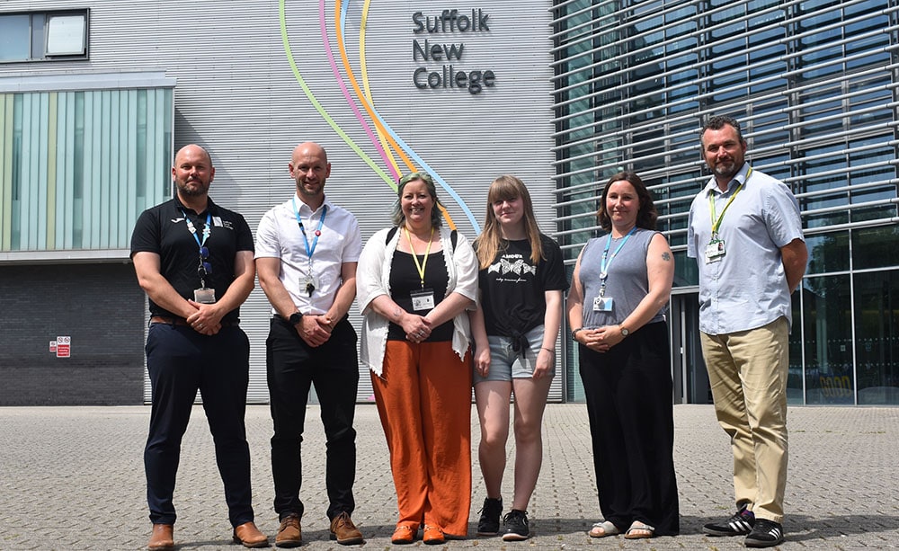 College staff and charity workers outside college building