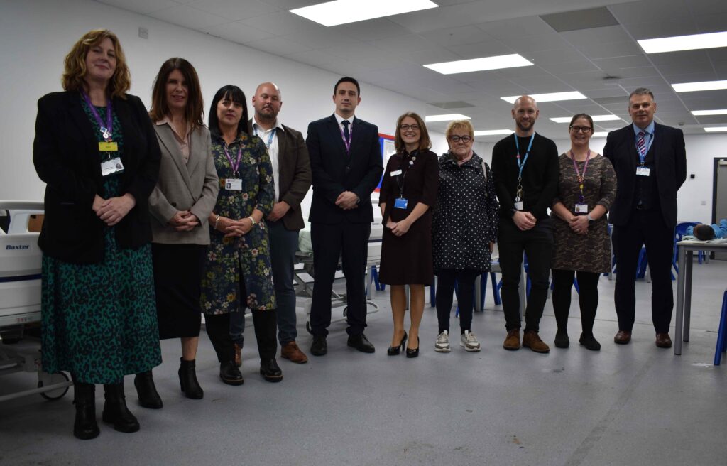 Suffolk New College staff standing in a classroom or training facility, showcasing professional and educational environment, focused on skills development and student success.