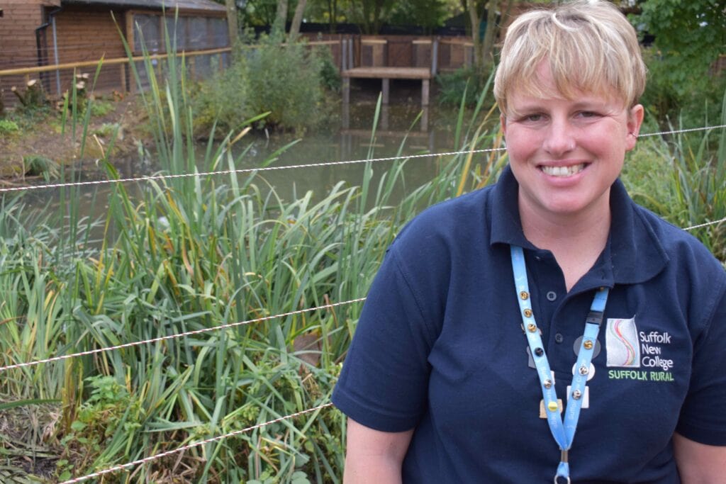 Suffolk New College lecturer outdoors near pond.
