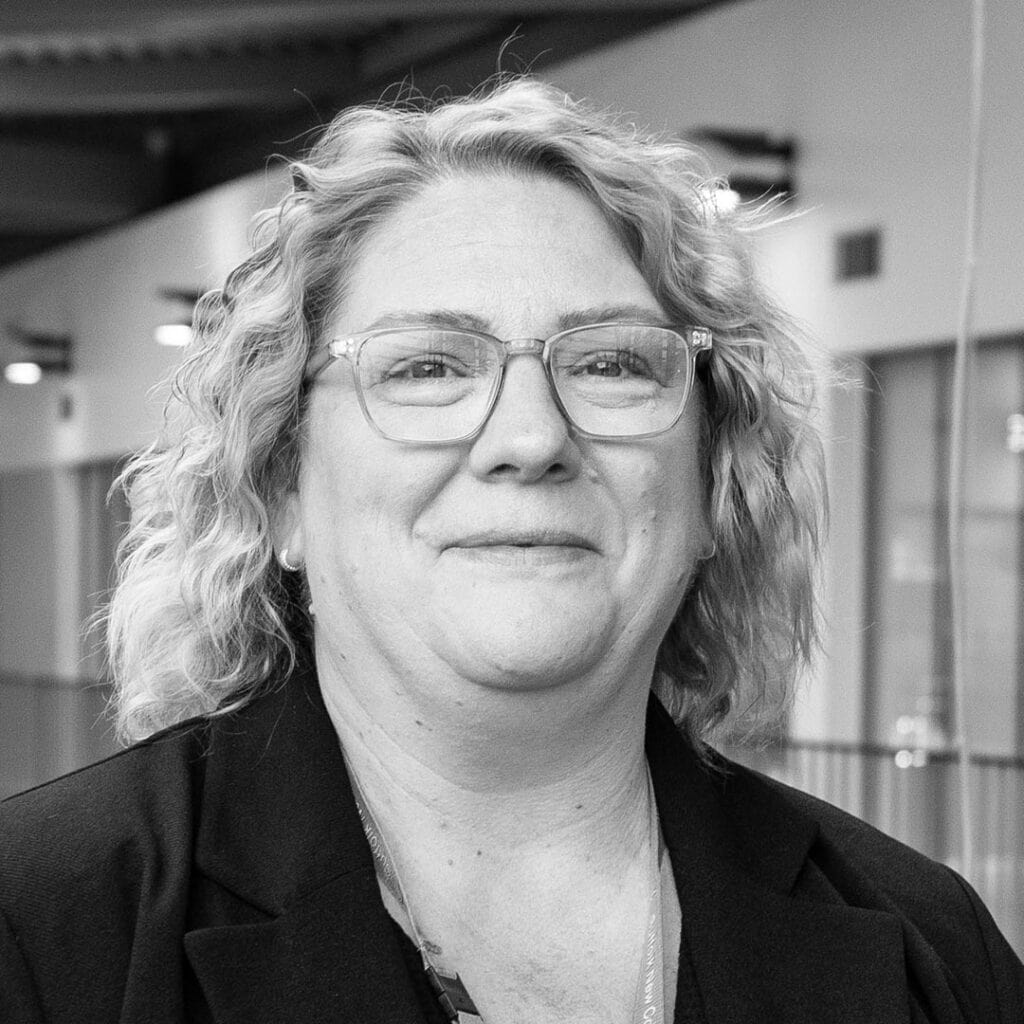 Diverse professional woman at Suffolk New College campus in black and white image.