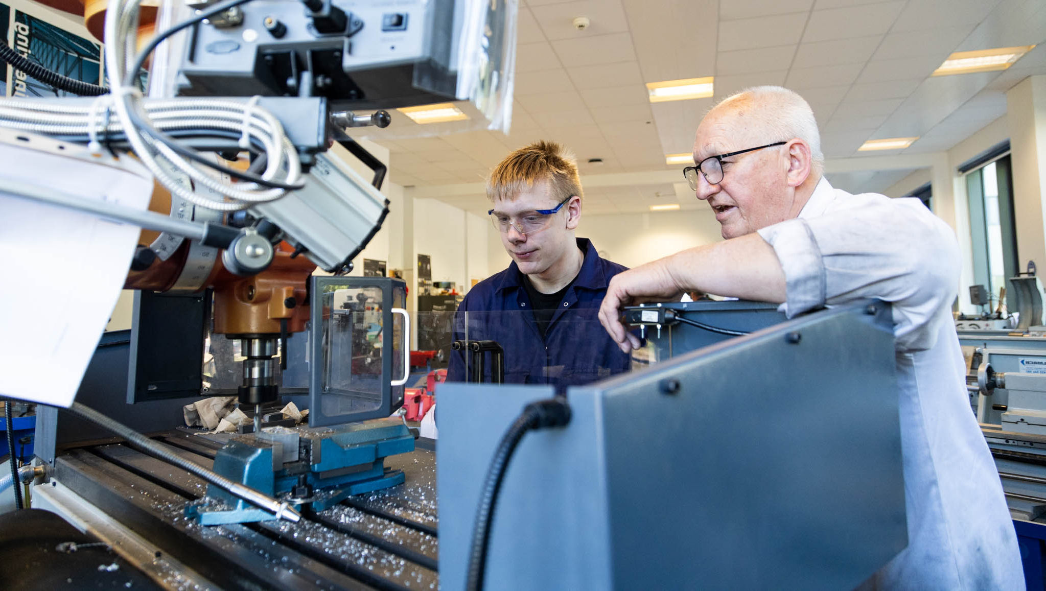 Advanced manufacturing engineering training at Suffolk New College with student and instructor using CNC machinery for technical skills development.