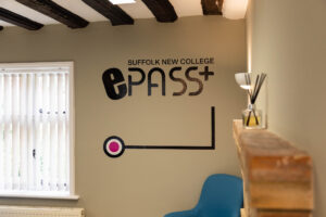 Modern Suffolk New College ePass lounge with College branding and seating area for students in en_gb.
