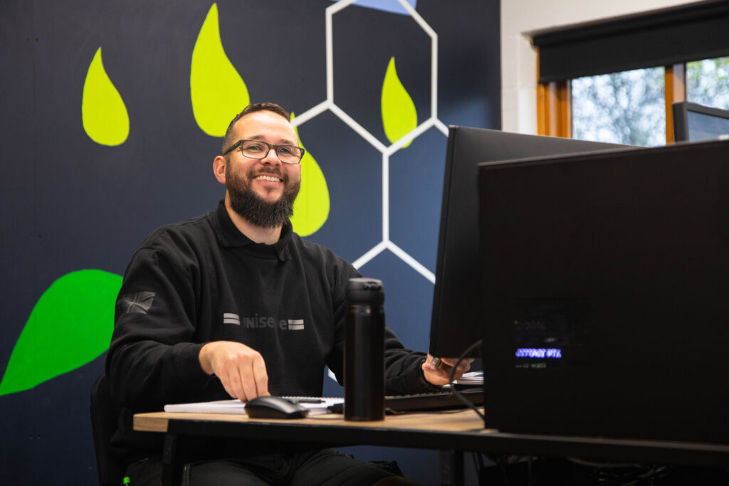 Innovative student at Suffolk New College working on a computer in a modern classroom, highlighting quality education and technology-focused courses.