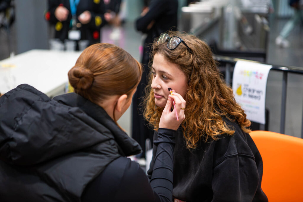 Makeup artist applying makeup to student at Suffolk New College.
