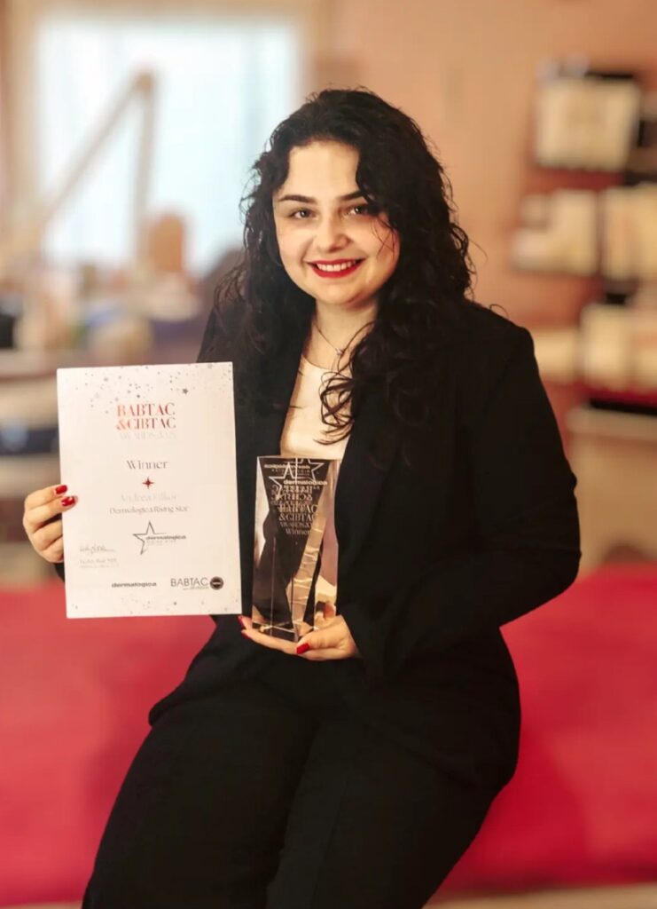 A smiling student holding a certificate and trophy, celebrating academic achievement and excellence in a college setting.