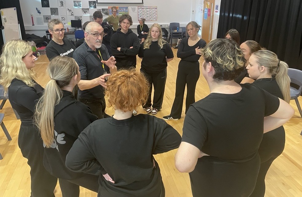 Diverse group of students in discussion with instructor at Suffolk New College, engaging in practical training to boost career skills.