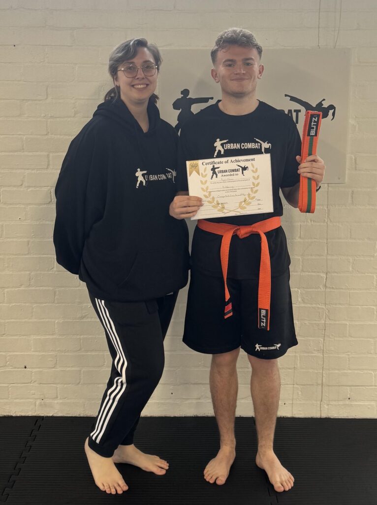 A student receiving a martial arts certificate at Suffolk New College combat training classroom.