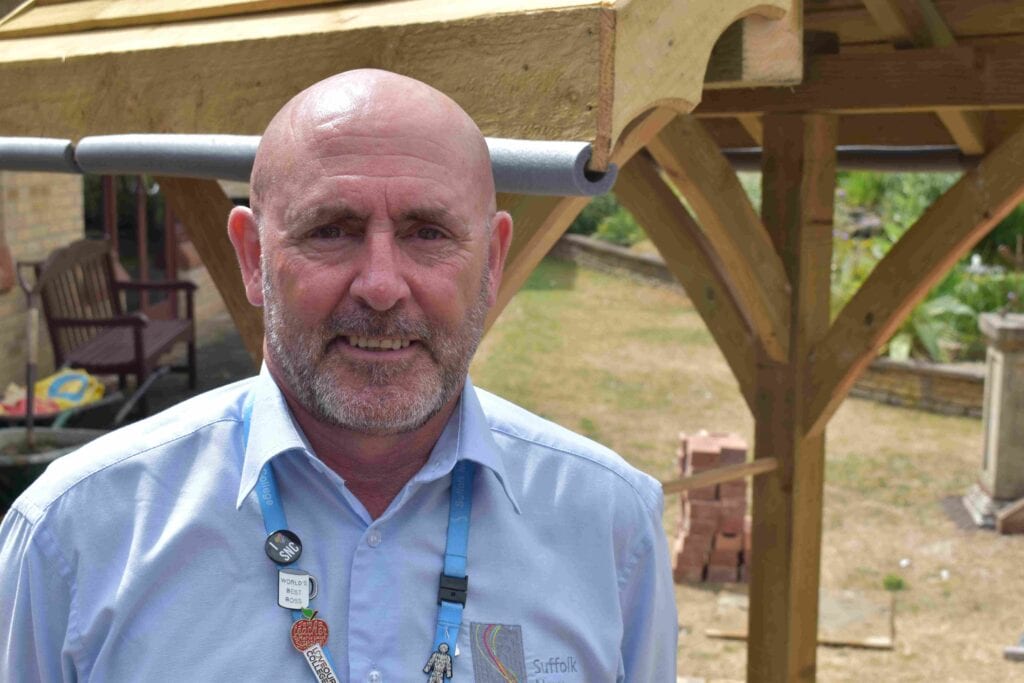 Senior instructor in woodworking class at Suffolk New College demonstrating craft skills.