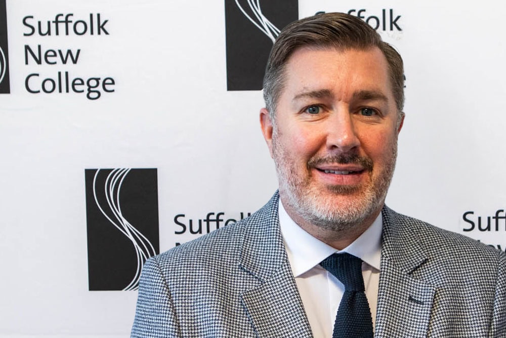 Suffolk New College campus with a professional man in business attire, showcasing education and training opportunities at Suffolk New College.