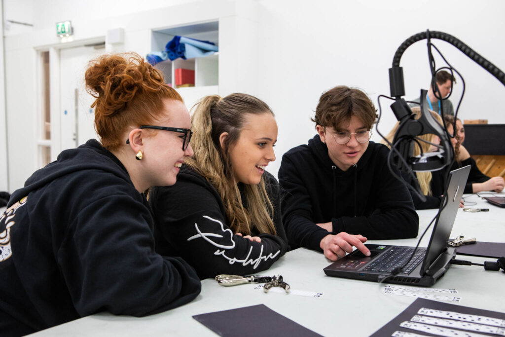 Diverse group of students engaging with media technology at Suffolk New College, demonstrating practical learning in media production and digital skills in a modern campus environment.