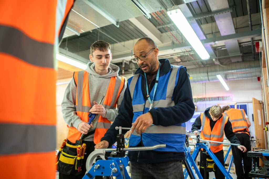 An instructor provides practical training to students in a workshop environment at Suffolk New College.
