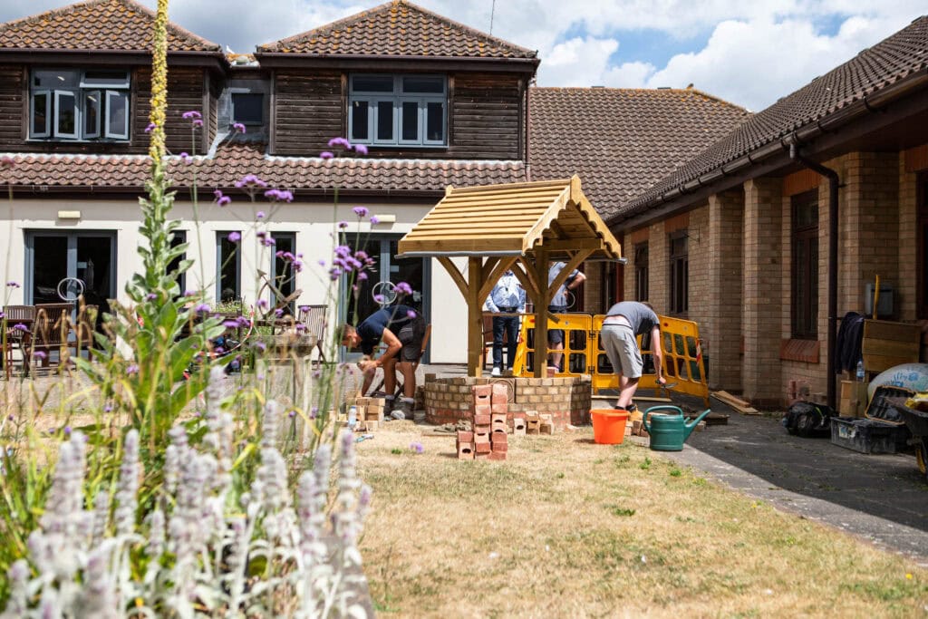 Students constructing a well, showcasing practical skills and outdoor learning activities at Suffolk New College campus.
