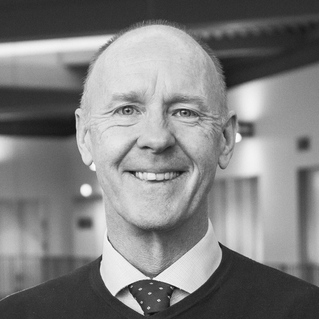 A smiling male student in a college corridor, representing Suffolk New College's inclusive learning environment and student success.