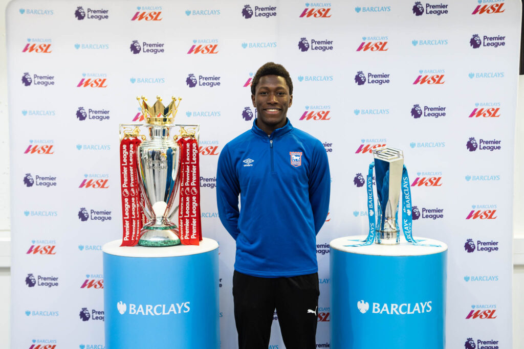 Young footballer with Premier League trophies at Ipswich event.