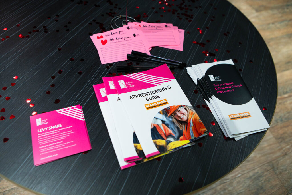 Display of Suffolk New College's apprenticeship and industry partner event materials, including guides and leaflets, celebrating industry engagement and student opportunities.