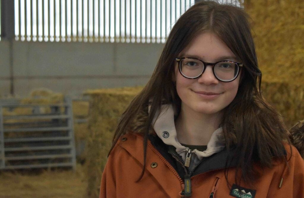 Young female student with glasses at Suffolk New College, involved in rural farming activities, highlighting increased female participation in agricultural courses.
