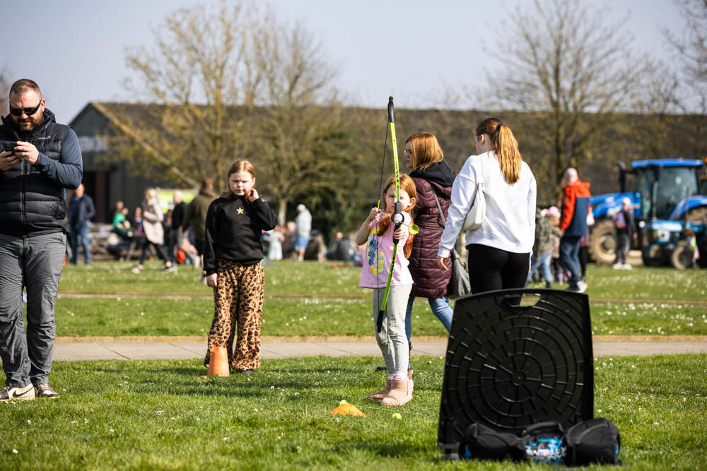 Families enjoying outdoor activities at Suffolk New College's spring fun day, featuring children, parents, and entertainment in a lively, community-focused event.