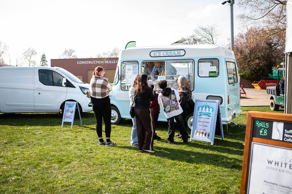 Families enjoy ice cream from a vintage van at Suffolk New College's spring fun day, attracting thousands for a day of lambtastic activities and community entertainment.