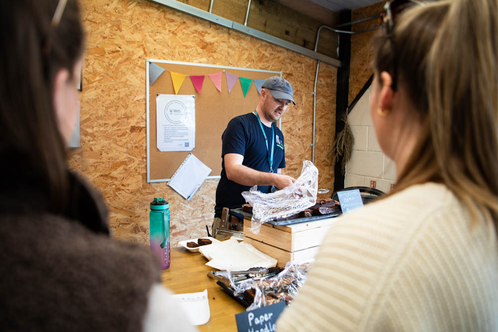 Suffolk New College staff demonstrating a craft activity at the 'lambtastic' spring family fun day, engaging visitors in hands-on learning and entertainment.